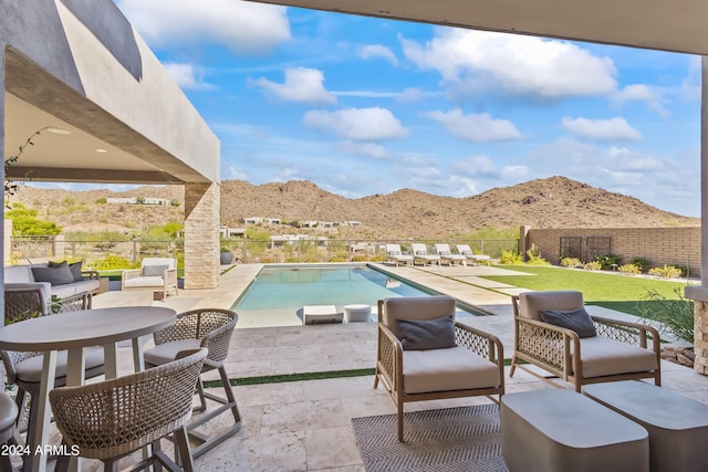 view of pool with an outdoor living space, a mountain view, and a patio area