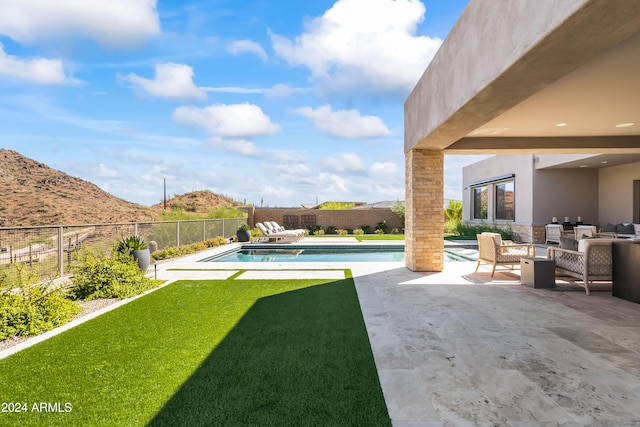 view of yard featuring a fenced in pool, a mountain view, and a patio