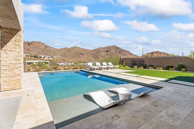 view of swimming pool featuring a mountain view, a lawn, and a patio area