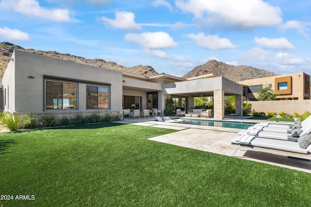 rear view of house featuring a patio area and a yard