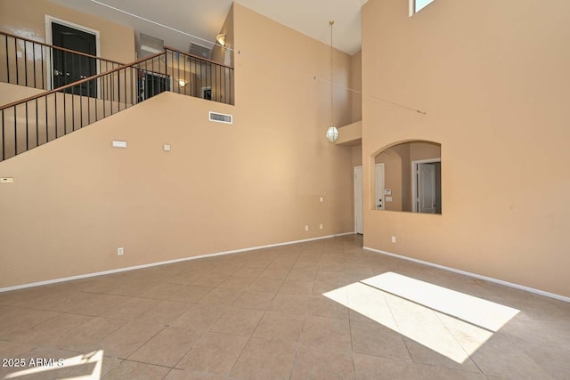 16112 W Durango St, Goodyear, AZ 85338 - unfurnished living room featuring tile patterned flooring, stairs, baseboards, a towering ceiling, and visible vents