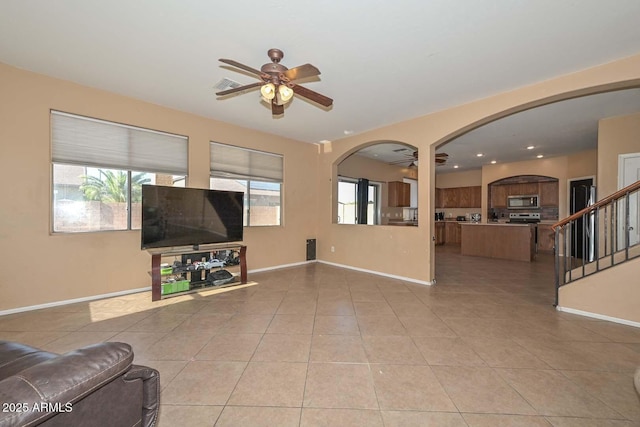16112 W Durango St, Goodyear, AZ 85338 - unfurnished living room with baseboards, a ceiling fan, arched walkways, and light tile patterned flooring