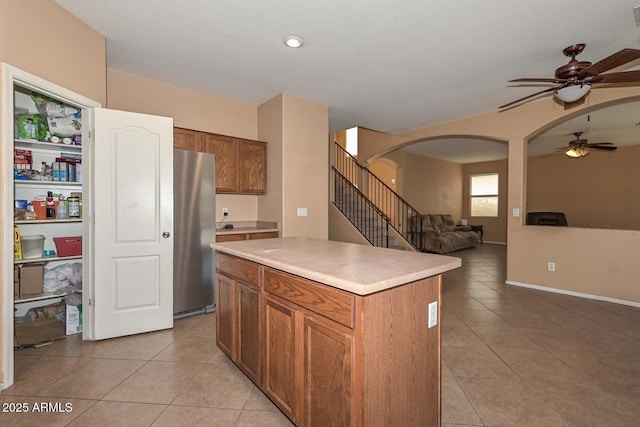 16112 W Durango St, Goodyear, AZ 85338 - kitchen with freestanding refrigerator, light tile patterned flooring, ceiling fan, and arched walkways