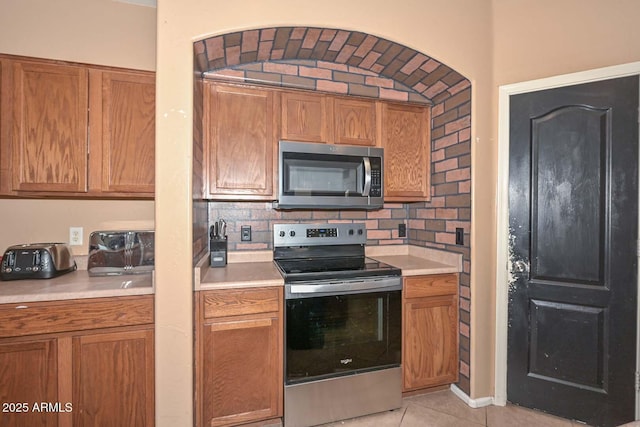 16112 W Durango St, Goodyear, AZ 85338 - kitchen with light countertops, light tile patterned floors, decorative backsplash, and stainless steel appliances
