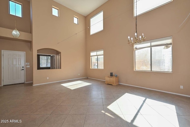 16112 W Durango St, Goodyear, AZ 85338 - unfurnished living room with an inviting chandelier, baseboards, a high ceiling, and tile patterned flooring