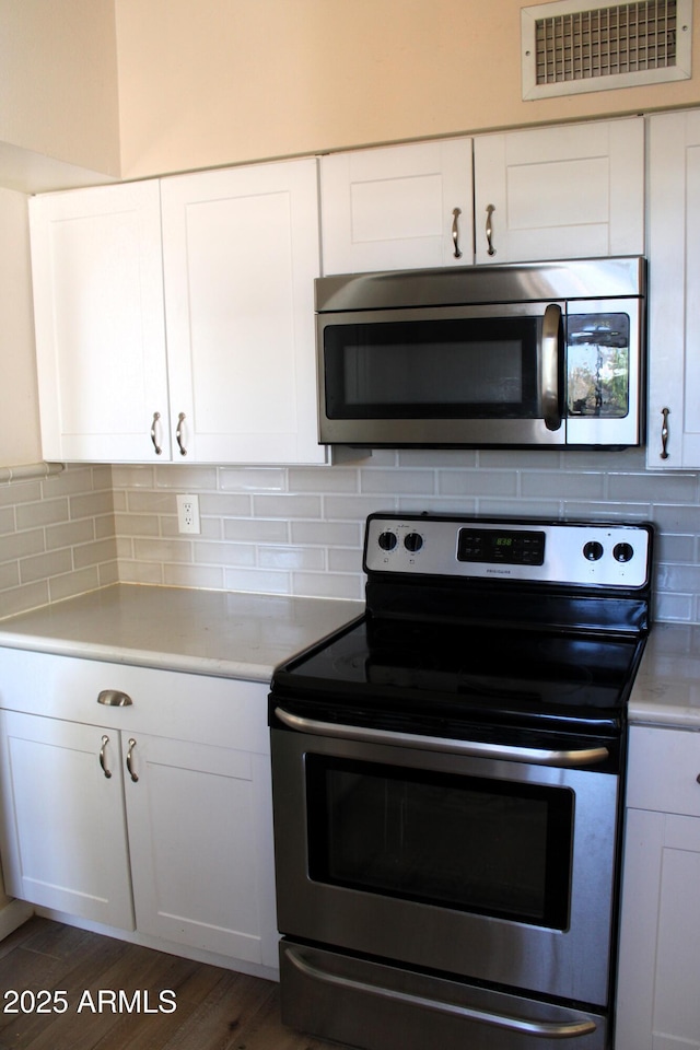 kitchen featuring visible vents, decorative backsplash, light countertops, and stainless steel appliances