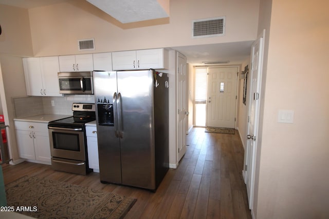 kitchen featuring visible vents, dark wood-style flooring, and stainless steel appliances