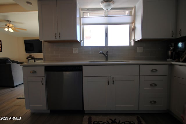 kitchen with wood finished floors, a sink, backsplash, and dishwasher