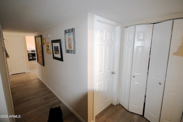 hallway with baseboards and wood finished floors