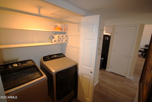laundry area with laundry area, independent washer and dryer, and wood finished floors