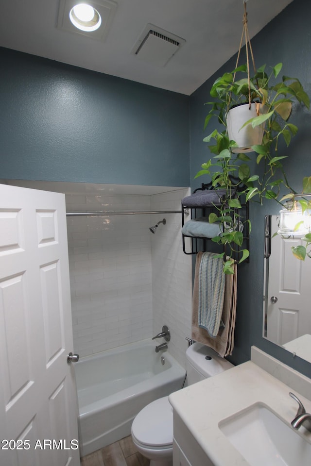 bathroom featuring visible vents, wood finished floors, vanity, toilet, and bathing tub / shower combination