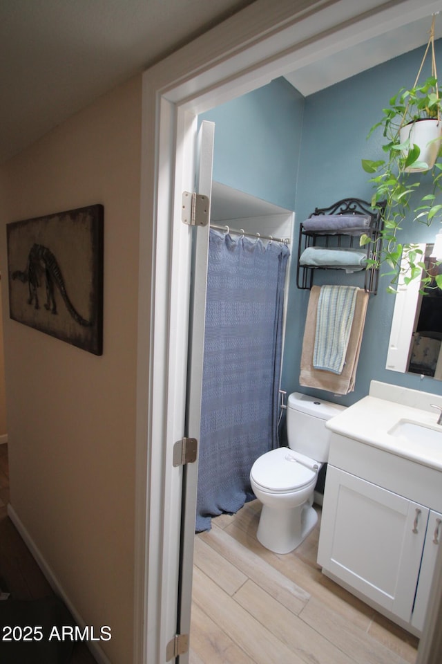 bathroom featuring vanity, wood finished floors, toilet, and a shower with curtain