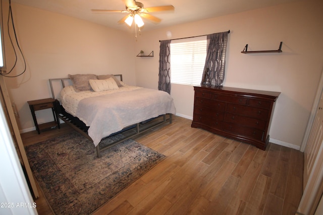 bedroom featuring baseboards, a ceiling fan, and wood finished floors