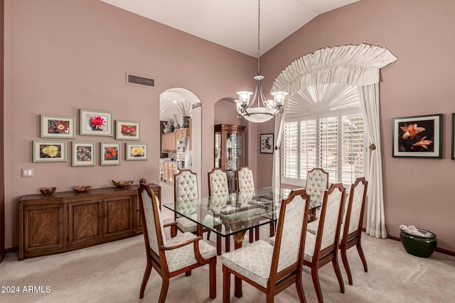 dining area featuring lofted ceiling, light carpet, and a chandelier