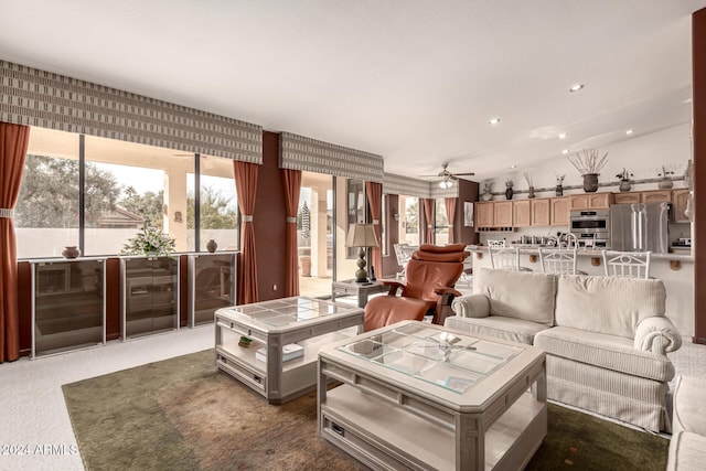 carpeted living room featuring ceiling fan and beverage cooler