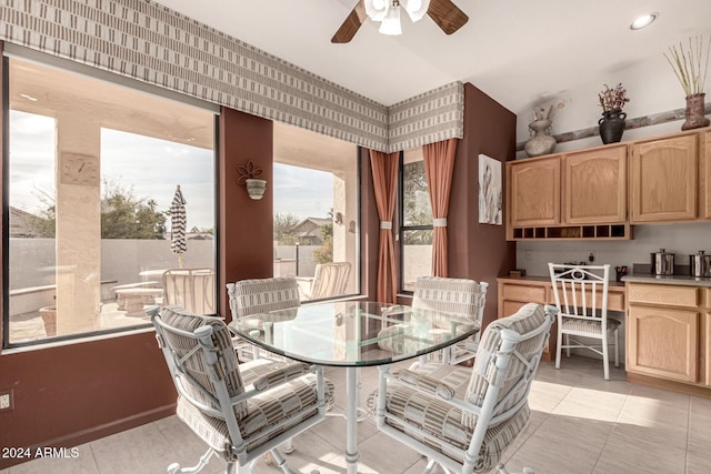 dining room with ceiling fan, light tile patterned flooring, and built in desk