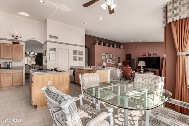 dining area featuring ceiling fan, light tile patterned floors, and vaulted ceiling