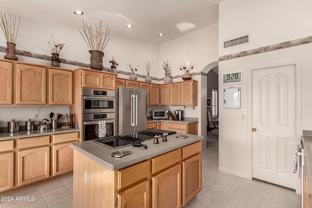 kitchen featuring a center island, light tile patterned floors, and stainless steel appliances