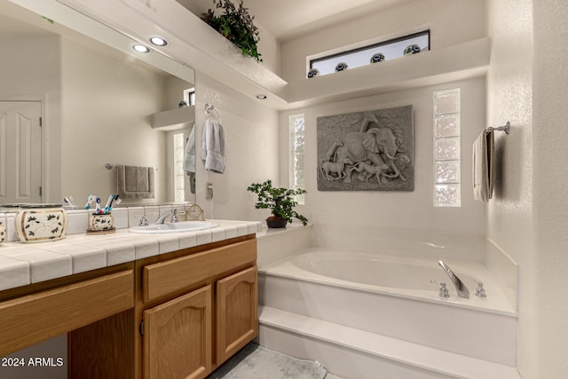 bathroom featuring vanity, a bathtub, and a wealth of natural light