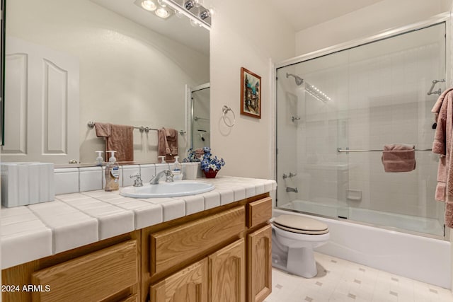 full bathroom with combined bath / shower with glass door, vanity, and toilet