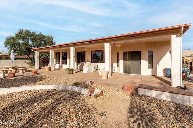 back of property featuring ceiling fan and a patio