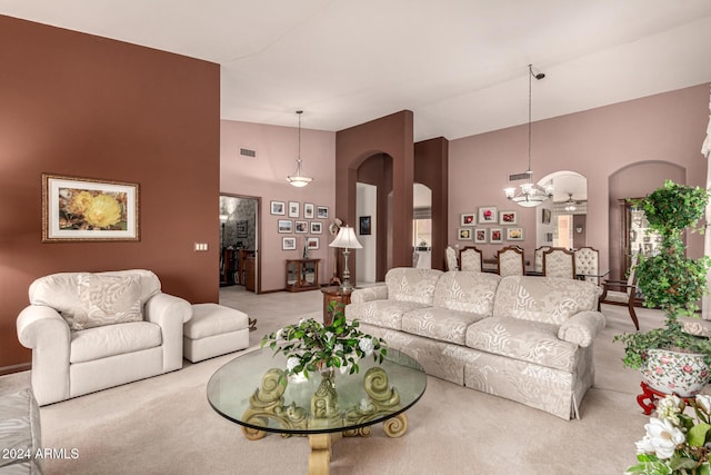 living room featuring light carpet, ceiling fan, and a high ceiling