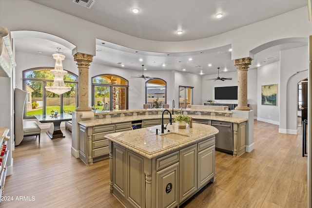 kitchen with a spacious island, light wood-style flooring, open floor plan, a sink, and ornate columns