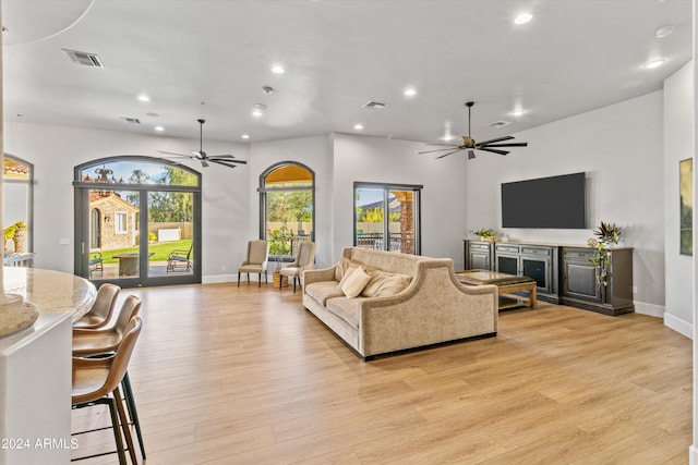 living area featuring light wood finished floors, a ceiling fan, visible vents, and recessed lighting