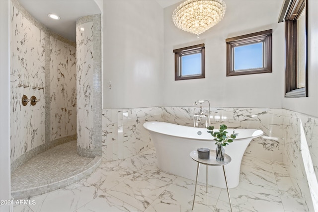 full bathroom featuring marble finish floor, wainscoting, a freestanding tub, and a marble finish shower