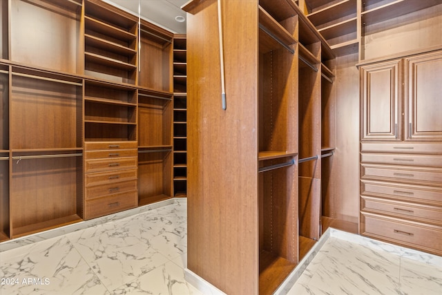 walk in closet with marble finish floor