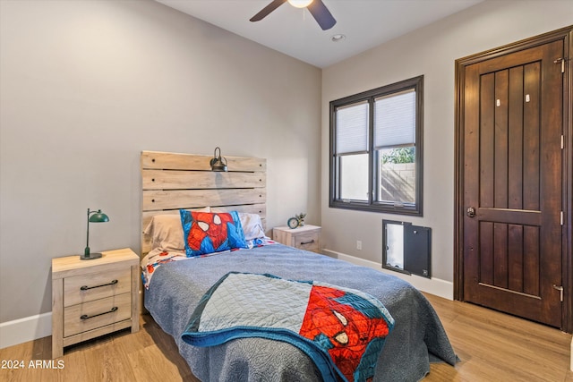 bedroom featuring wood finished floors, a ceiling fan, and baseboards