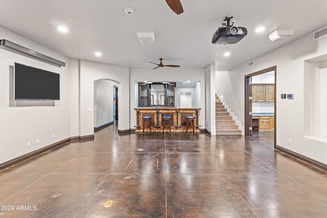 living area featuring baseboards, arched walkways, and recessed lighting