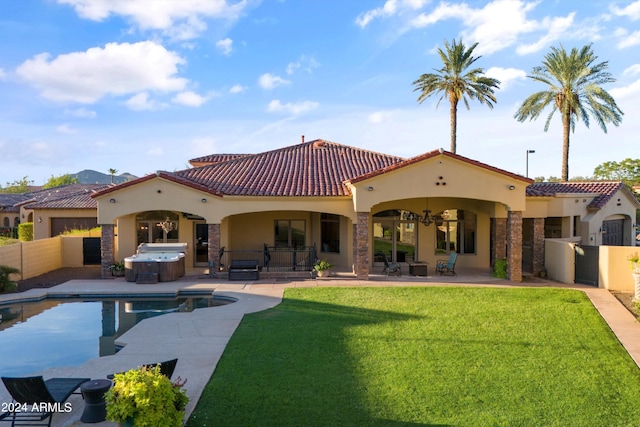 rear view of property with a fenced backyard, a tile roof, a lawn, a patio area, and a hot tub