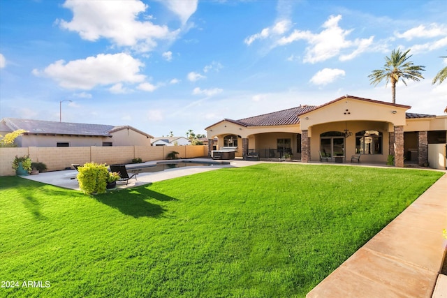 back of house featuring a yard, a patio, stucco siding, stone siding, and a fenced backyard