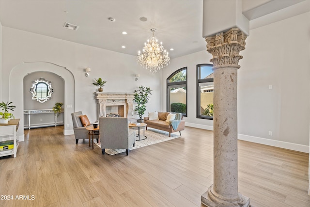 interior space with arched walkways, visible vents, a high end fireplace, light wood-type flooring, and decorative columns