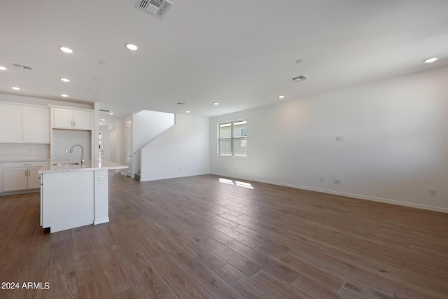 unfurnished living room with sink and dark wood-type flooring