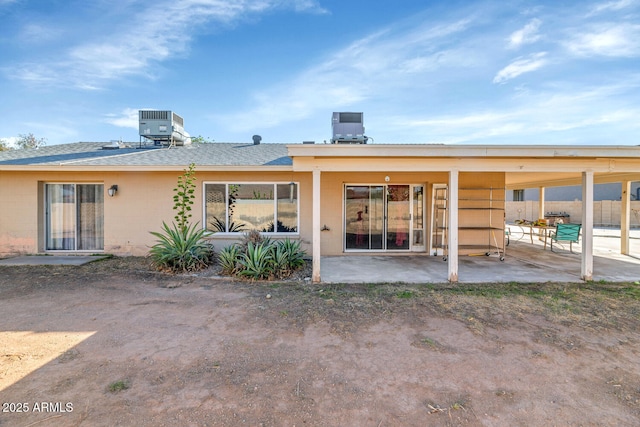 back of house featuring a patio, concrete block siding, and central AC