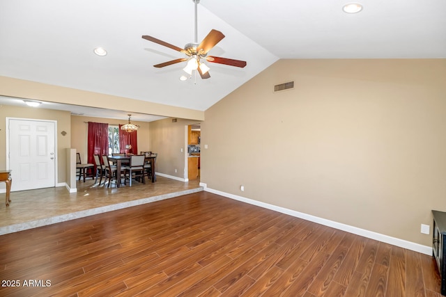 interior space with wood finished floors, visible vents, baseboards, lofted ceiling, and ceiling fan with notable chandelier