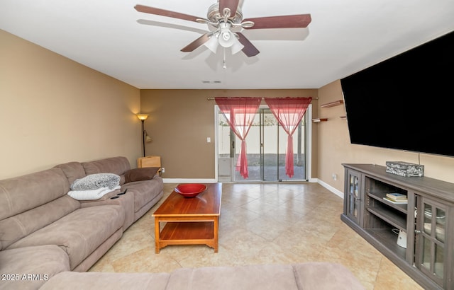 living area featuring light tile patterned flooring, a ceiling fan, visible vents, and baseboards