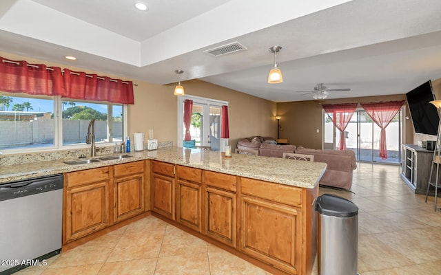 kitchen featuring visible vents, a healthy amount of sunlight, a peninsula, stainless steel dishwasher, and a sink