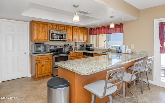 kitchen with visible vents, a peninsula, a sink, appliances with stainless steel finishes, and a raised ceiling