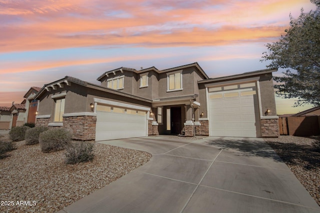 19054 W Becker Ln, Surprise, AZ 85388 - prairie-style home with stone siding, concrete driveway, stucco siding, and an attached garage
