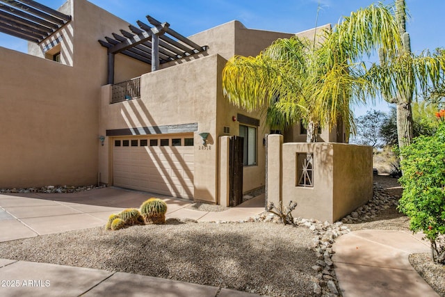 view of side of property with driveway, a pergola, and stucco siding