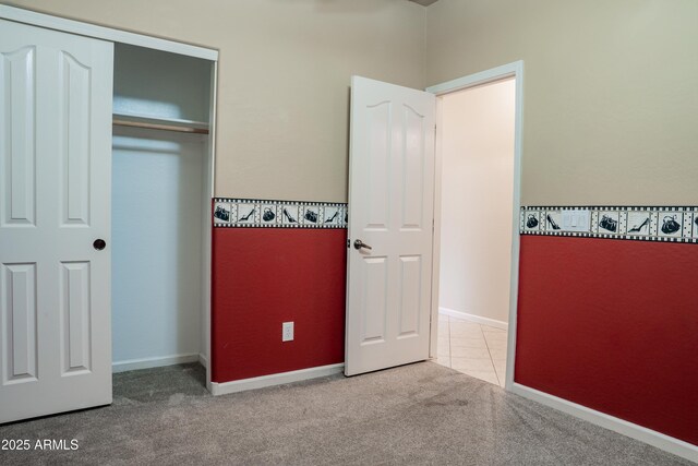 unfurnished bedroom featuring a closet, baseboards, and carpet floors
