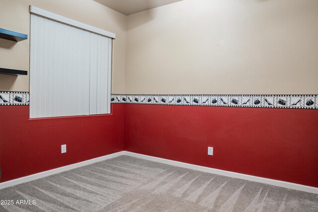 empty room featuring carpet floors and baseboards