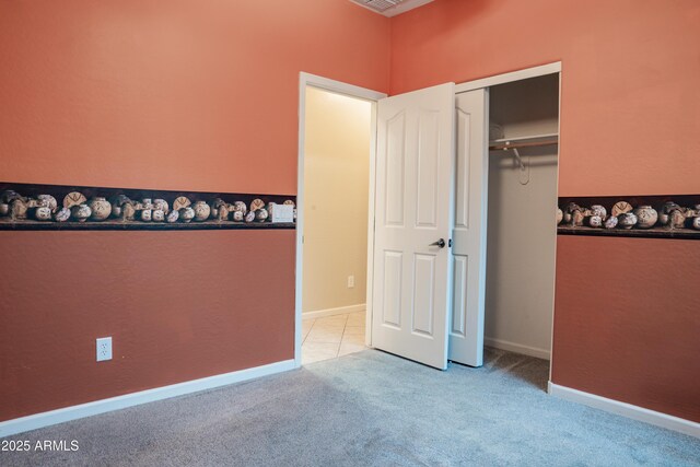 unfurnished bedroom featuring light colored carpet and a closet