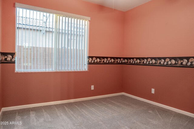 carpeted spare room featuring baseboards