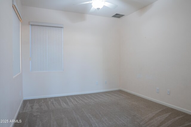 unfurnished room with visible vents, ceiling fan, carpet floors, and baseboards