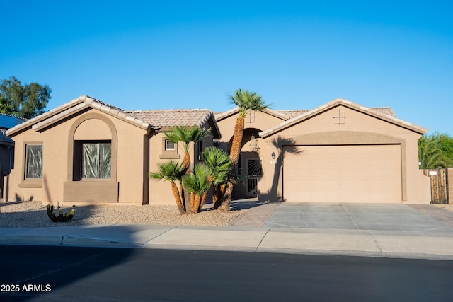 view of front of property with an attached garage, driveway, stucco siding, and a tiled roof