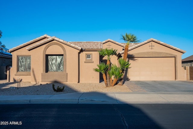 view of front of home featuring a tile roof, concrete driveway, stucco siding, and an attached garage